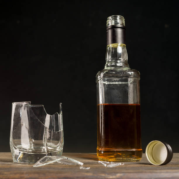 割れたガラスとウイスキーのボトル。アルコール依存症による人生の台無しの概念。 - whisky alcohol pouring glass ストックフォトと画像