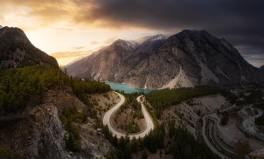 Aerial View of a Scenic Road in the Canadian Mountain Landscape during a cloudy sunset. Sky Replacement Composite. Taken in Lillooet, BC, Canada.