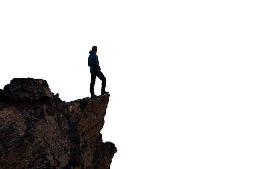 Adventurous Man Hiker Standing on top of a Steep Rocky Cliff. White Background Isolated Cutout. Perfect for Image Composites. Graphic Resource. Concept: Adventure, Explore, Hike, Lifestyle