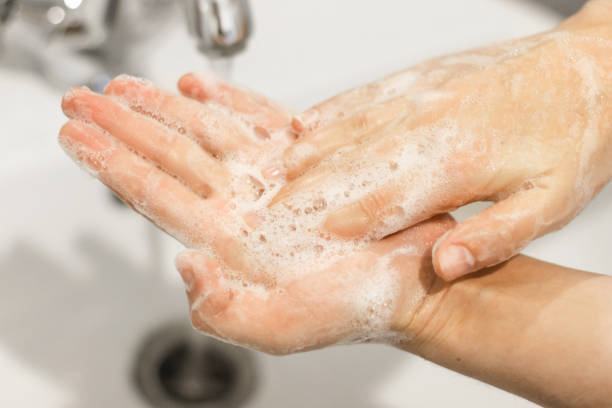istock Washing hands. Rubbing palms, washing hands with antibacterial soap and in proper technique on background of flowing water in white bathroom. Prevention coronavirus. Cleaning and disinfecting hands 1220272329