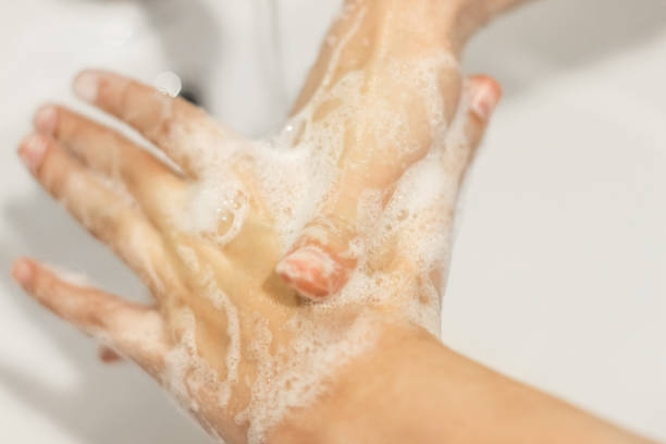 istock Rubbing big thumb, Washing hands with antibacterial soap in proper technique on background of flowing water in white bathroom. Prevention coronavirus. Cleaning and disinfecting 1220272335