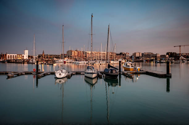 Sailing boats in the marina of Zeebrugge during blue hour. Long exposure image stock photo