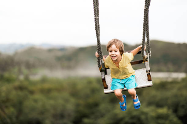 istock Happy little boy having fun while swinging in nature. 1220273330