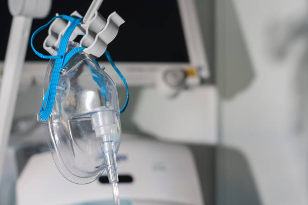 Adult oxygen face mask, on background medical ventilator in ICU in hospital. stock photo