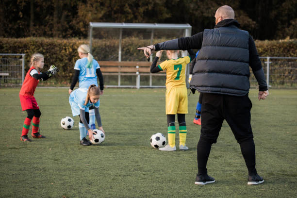 istock Soccer father coaching football daughter's team during a training session 1220273450
