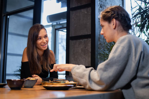 istock Two girlfriends chatting and having some snacks in a cafe 1220278231