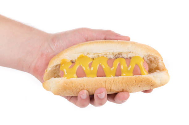 istock Hotdog with mustard in a hand. 1220278235