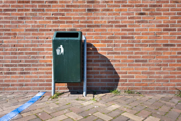 istock Modern green Metallic trash bin in a sunny urban environment 1220279145