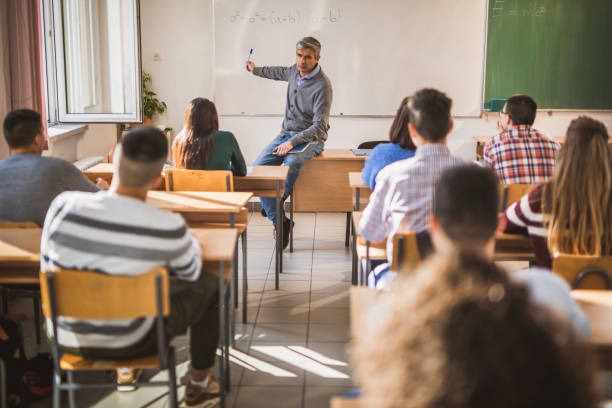 istock Male teacher teaching mathematics to his students in the classroom. 1220279359