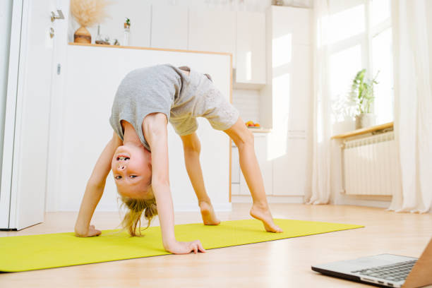 istock Little boy doing full bridge exercise, looking at camera. On isolation at home. 1220281560