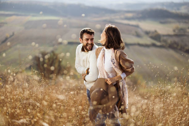 istock Young cheerful couple having fun while walking in a meadow. 1220283182