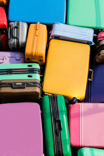 A variety of colorful luggage that is waiting to be transported to various places.