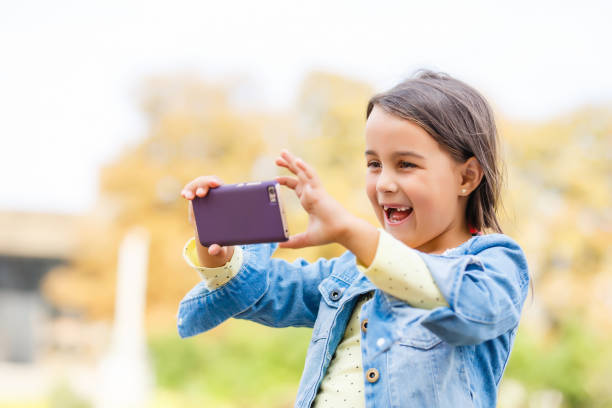 istock Video streaming. Adorable child learning new technology. Little girl using mobile phone. Small girl child with smartphone. Cute mobile phone technology user. Watching video on mobile device. 1220286112