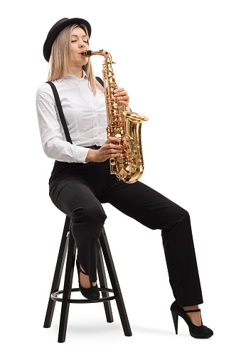 Young blond female artist playing a saxophone isolated on white background