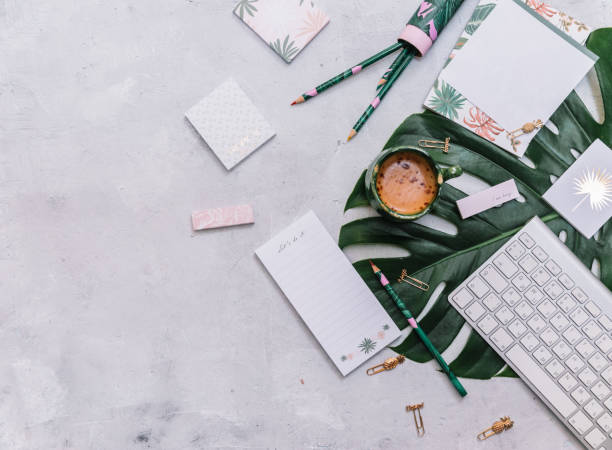 istock Modern white office desk table with coffee cup, keyboard and accessories. Top view, flat lay 1220289520