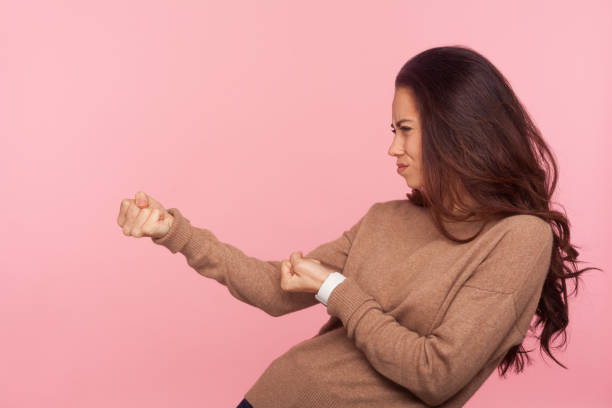 portrait of diligent purposeful young woman with brunette hair pretending to pull invisible rope, holding something heavy - imagination fantasy invisible women imagens e fotografias de stock