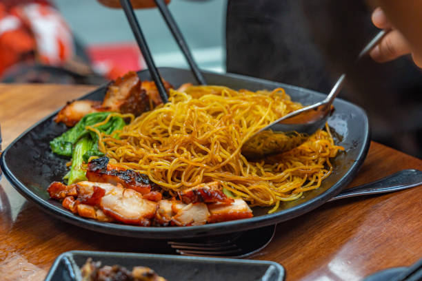 istock People using chopsticks eating Chinese honey grilled pork noodles 1220294281