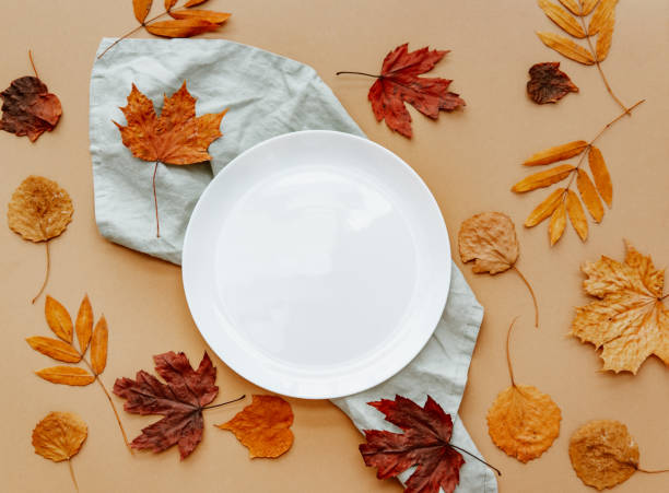istock White porcelain plate with autumn leaves mockup. Flat lay, top view 1220294504