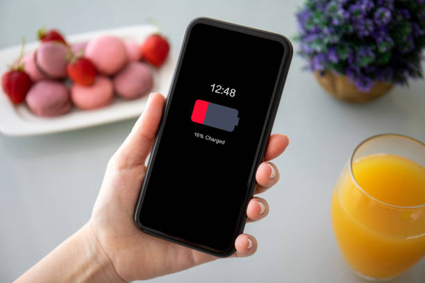 istock female hands holding phone with low charged battery on screen 1220296177