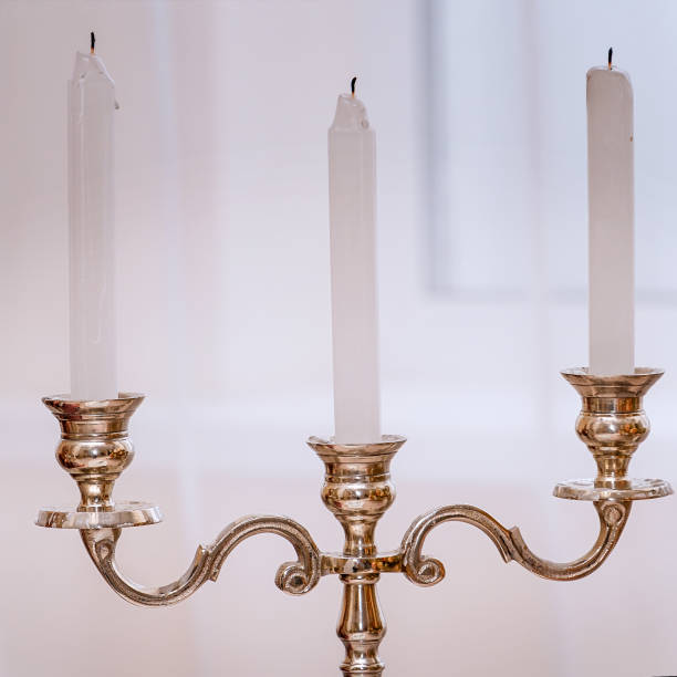 istock Antique gold candlestick with three candles on light background 1220297109