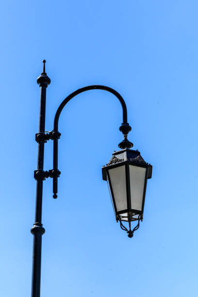 istock Old lantern on a metal post against blue sky 1220297853