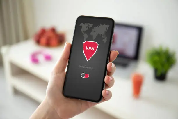 Photo of female hand holding phone with app vpn on the screen