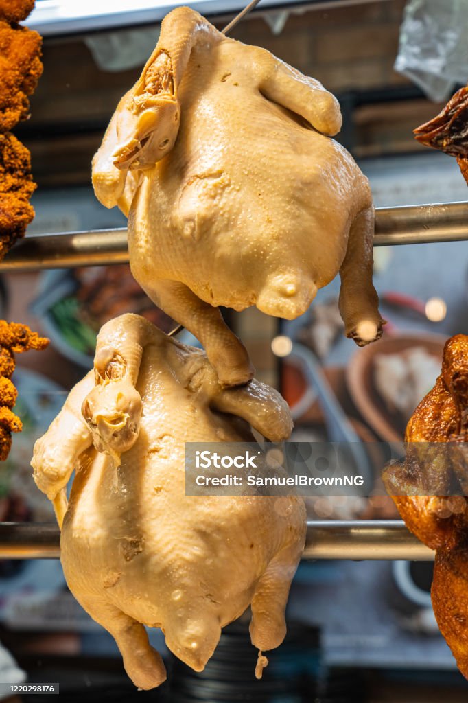Closeup photo of whole cooked chicken displayed at Chinese restaurant Crispy roasted chickens hanging at Chinese restaurant showcase window Chicken Meat Stock Photo