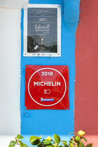 Burano, Italy - JUL 04, 2019: The sign plate and michelin's rating mark of Al gatto nero restaurant, Venice