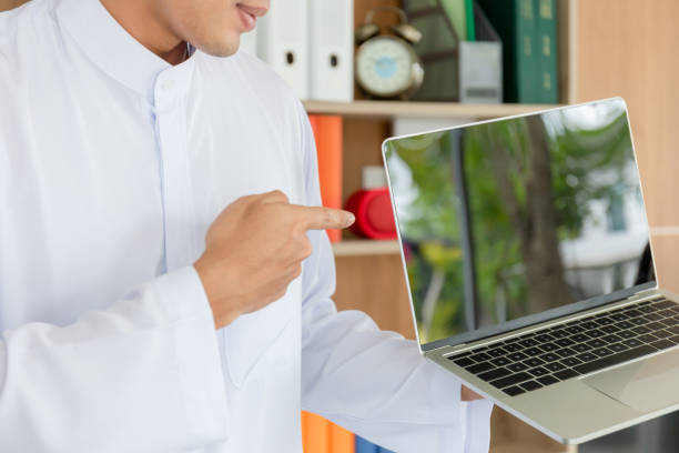 istock Young business arab middle eastern muslim man showing laptop screen in office 1220299601