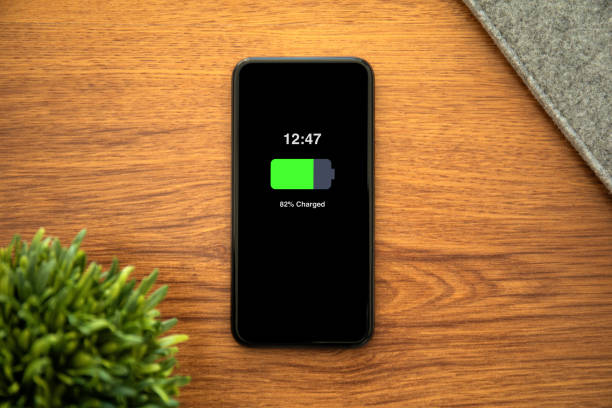 istock Phone with charged battery on the screen table in office 1220300813