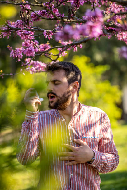 istock Young man treating asthma with inhaler 1220300991