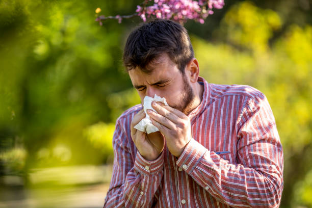 istock Ill or allergic man coughing in a park 1220301072