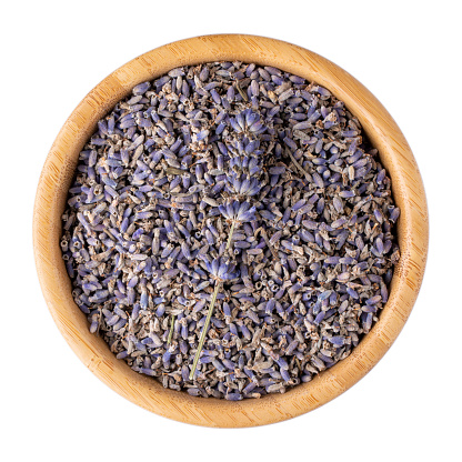 Dried lavender flowers in wooden bowl isolated on white. Top view.