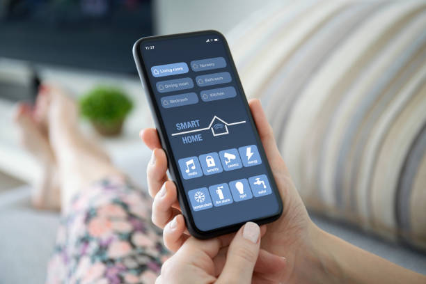istock female hands holding phone with app smart home on screen 1220301452