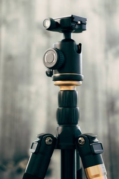 istock Black photo tripod on a gray wooden background 1220302214