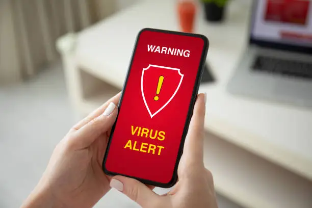 Photo of female hands holding phone with warning virus alert alarm