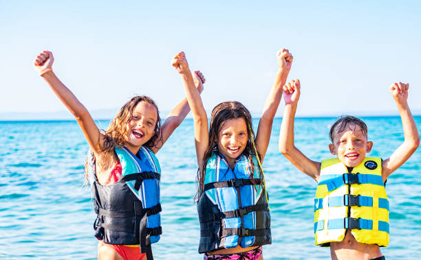 los niños se están preparando para montar en el barco. - life jacket little girls motorboating sailing fotografías e imágenes de stock