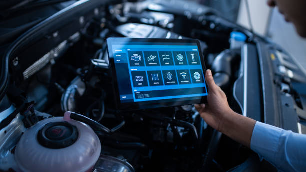 istock Car Service Manager or Mechanic Uses a Tablet Computer with a Futuristic Interactive Diagnostics Software. Specialist Inspecting the Vehicle in Order to Find Broken Components In the Engine Bay. 1220304818