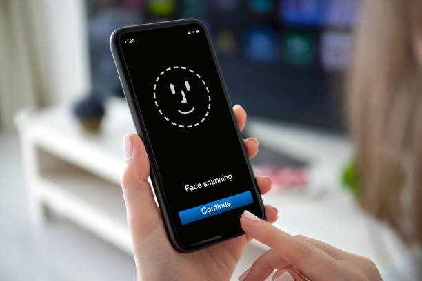 istock female hands holding phone with face ID scanning on screen 1220305520