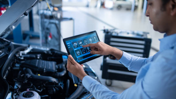 istock Car Service Manager or Mechanic Uses a Tablet Computer with a Futuristic Interactive Diagnostics Software. Specialist Inspecting the Vehicle in Order to Find Broken Components In the Engine Bay. 1220306194