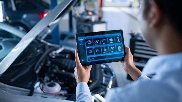 istock Car Service Manager or Mechanic Uses a Tablet Computer with a Futuristic Interactive Diagnostics Software. Specialist Inspecting the Vehicle in Order to Find Broken Components In the Engine Bay. 1220306435