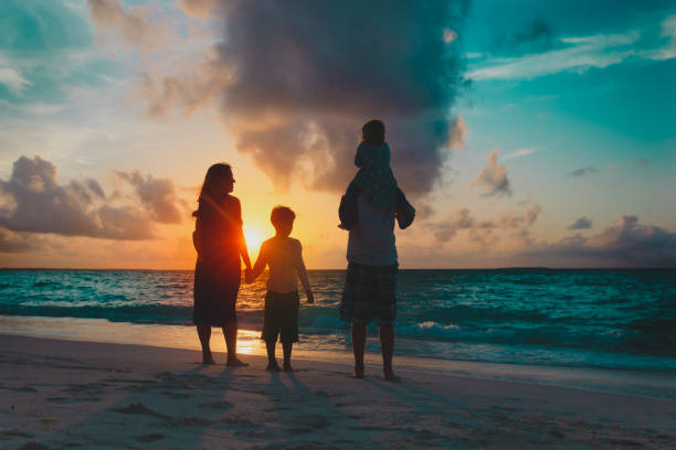 istock happy family with tree kids looking at sunset on beach 1220306513