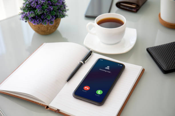 istock phone with incoming call on the screen notebook in office 1220307934