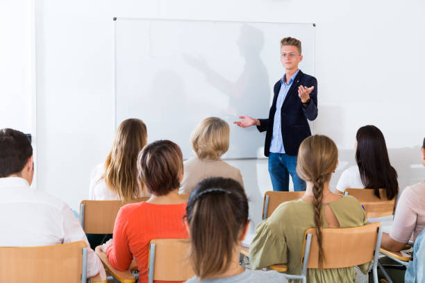 istock Young male giving presentation for audience 1220308389