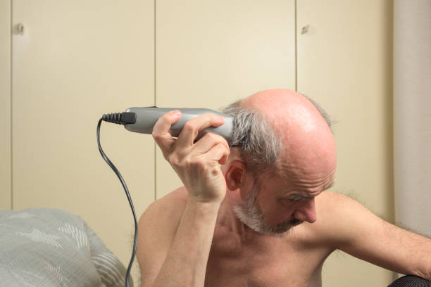 istock Bald Mature Man Trimming Hair - Series 1220308962