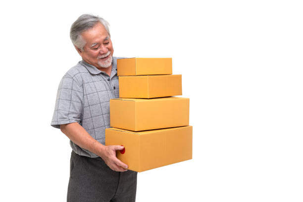 istock Happy asian senior man holding package parcel box isolated on white background, Delivery courier and shipping service concept 1220309862