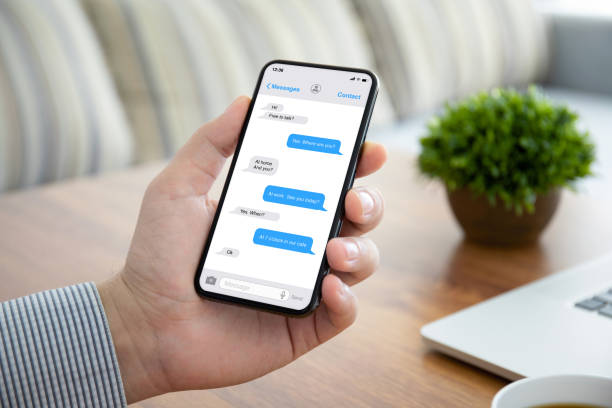 istock male hand holding phone with app messenger on the screen 1220309937