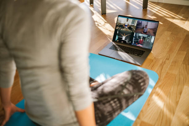 istock Group of people practicing yoga via video conference 1220313968