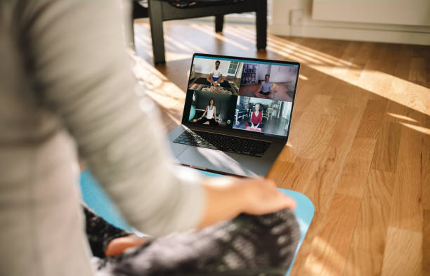 istock Group of people practicing yoga with trainer via video conference 1220314025