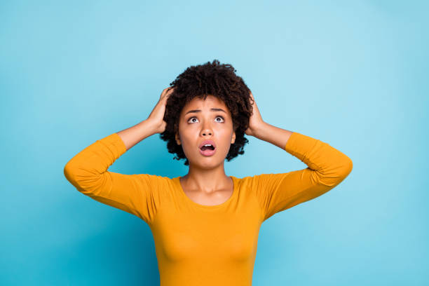 istock My god what should i do. Frustrated anxious afro american have many problems get fired job touch hands head look copyspace up wear stylish trendy pullover isolated blue color background 1220314382